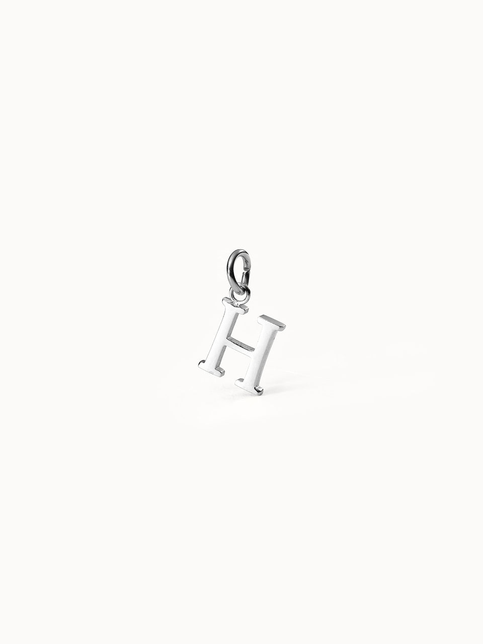 Purelei Pure H Charm aus nickelfreiem, silbernem Edelstahl, klar und elegant, minimalistisch auf hellem Hintergrund.