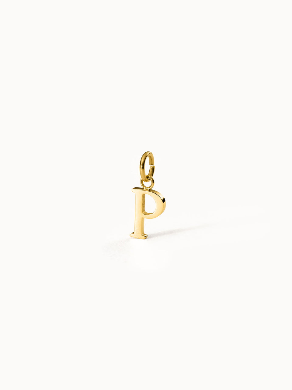 PURELEI Pure P Charm, goldener Buchstaben-Anhänger aus Edelstahl, elegant, minimalistisch, warmes Licht auf weißem Hintergrund