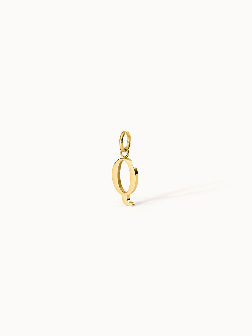Purelei Pure Q Charm aus goldfarbenem Edelstahl, eleganter Buchstabenanhänger mit klarem Design vor hellen Hintergrund.