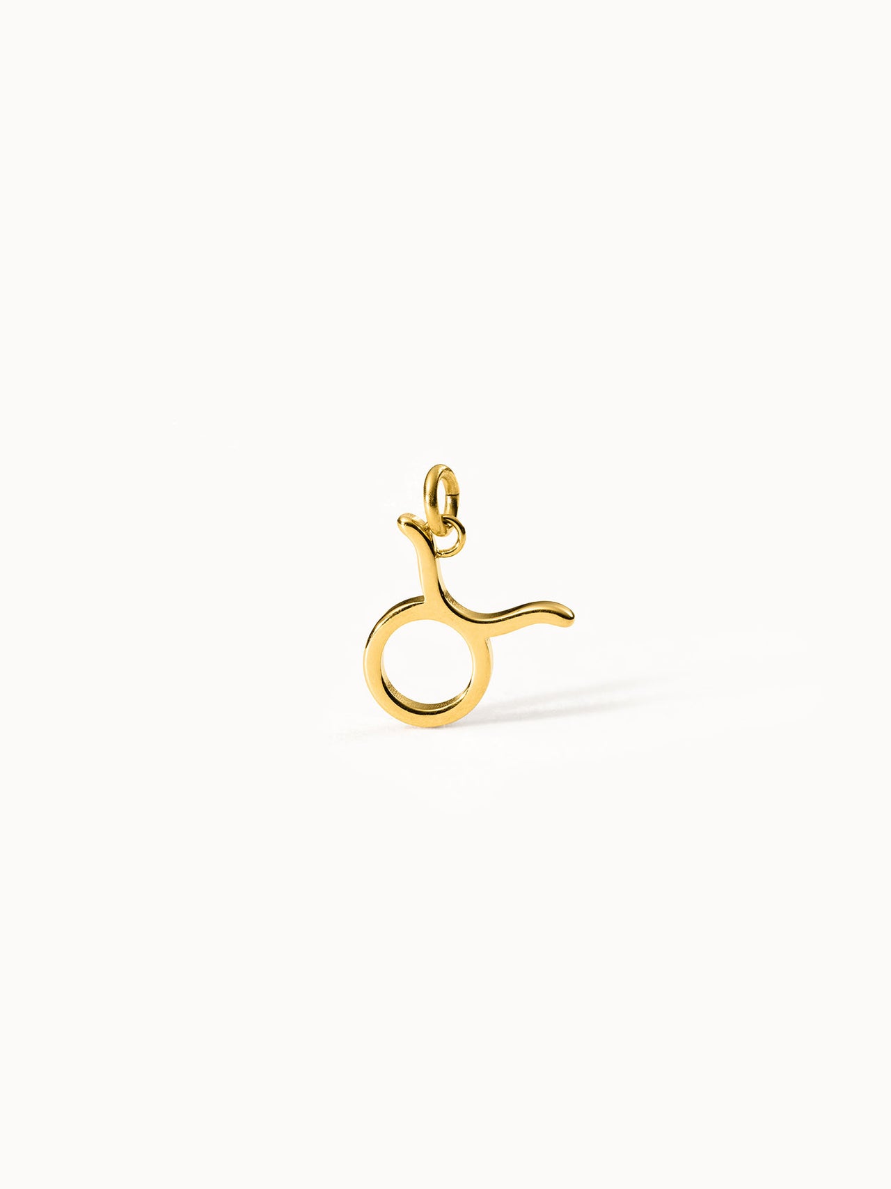 Stier Zodiac Charm aus vergoldetem Edelstahl, minimalistisches Design auf hellem Hintergrund, PURELEI Eleganz.