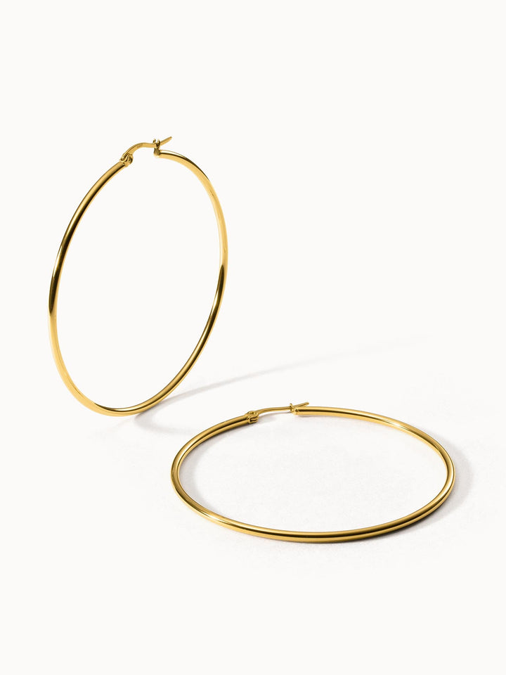 Goldene Creolen von PURELEI, elegant und zeitlos, auf hellem Hintergrund.