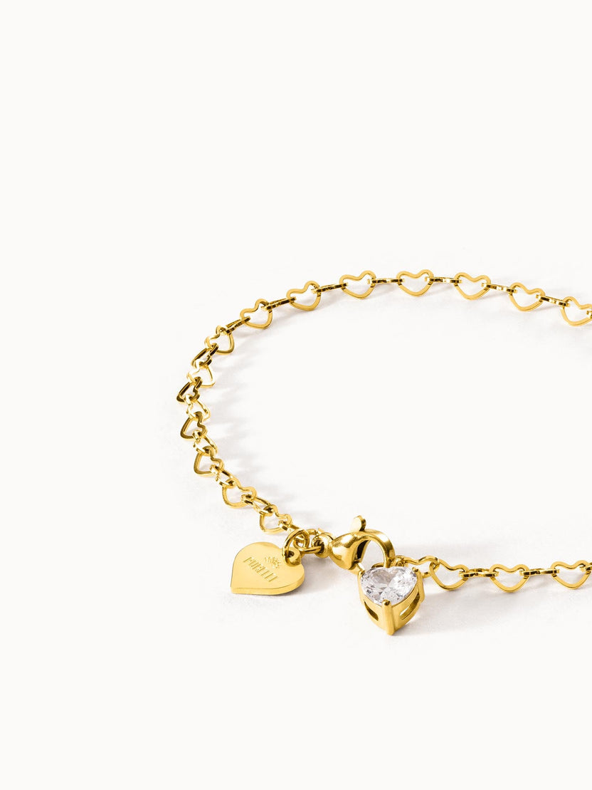 Goldenes Armband mit Herzdesign und Kristallanhänger von PURELEI, elegant und verspielt.