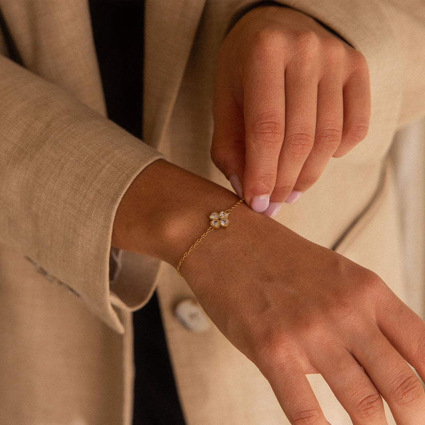 Roségoldenes Armband mit blütenförmigem Anhänger, getragen in eleganter Umgebung - PURELEI.