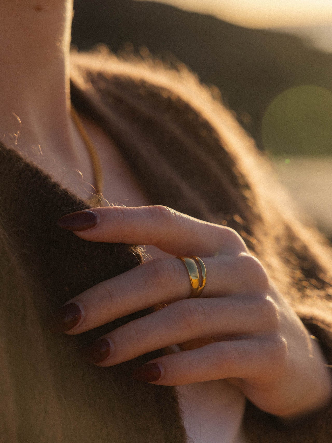 Verstellbarer PURELEI Twin Tides Ring in 18K Gold, geschwungene Bänder, elegant und feminin im warmen Abendlicht.
