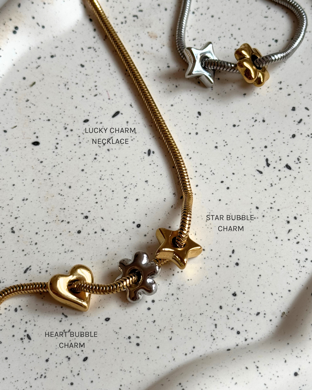 Star Lucky Charm aus gold- und silberfarbenem Edelstahl, nickelfrei, auf zarter PURELEI Kette, elegant und zeitlos.