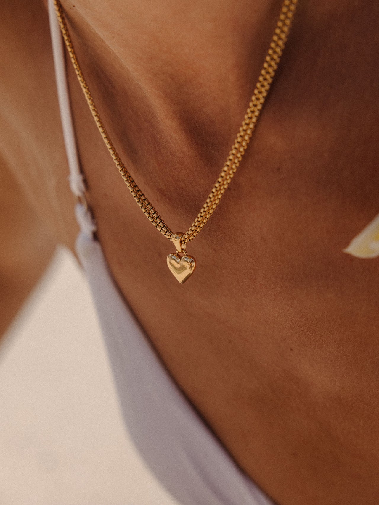 PURELEI Aloha Love Charm Herzanhänger in Gold aus Edelstahl, elegant und warm, am Schlüsselbein getragen.