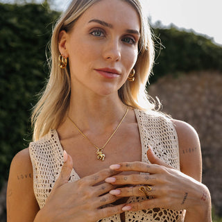 Goldene Kette mit Anhänger und Creolen, PURELEI, in warmem Licht, elegant und feminin.