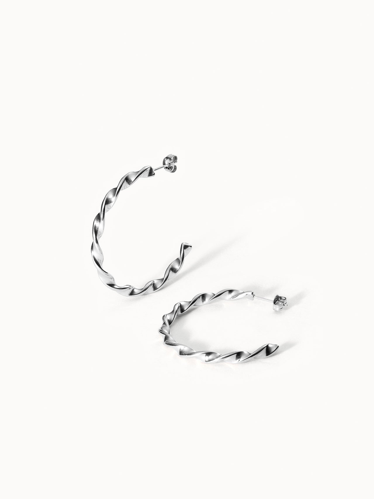 PURELEI Kaula Creole Ohrringe aus nickelfreiem, gedrehtem silberfarbenem Edelstahl, elegant minimalistisch inszeniert.