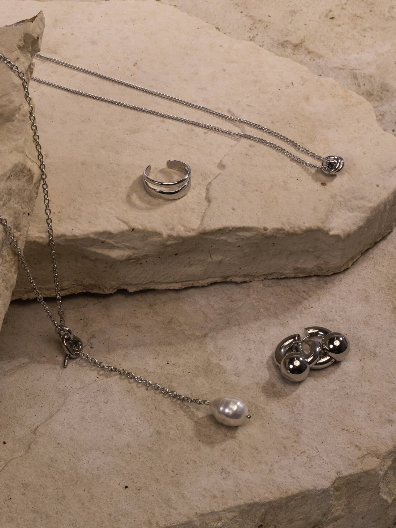 PURELEI Aloha Schmuckset mit nickelfreiem Silberring, Perlenkette, Knoten- und Creolen-Design, natürlich und elegant arrangiert.