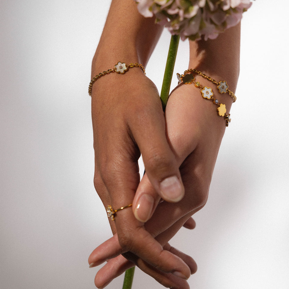 PURELEI Flourish Armband in Gold mit Perlmutt-Blütenanhänger, elegant getragen für feminine Leichtigkeit und Island-Spirit.