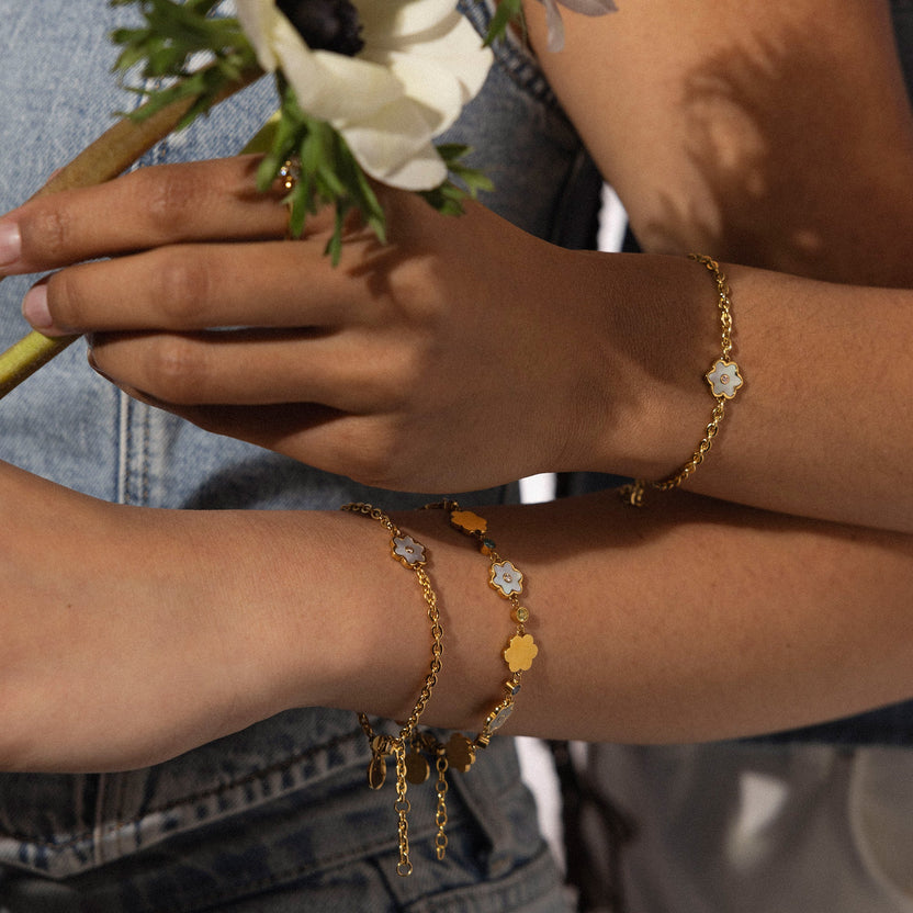 PURELEI Flourish Armband in Gold mit Blütenanhänger aus Perlmutt, elegant am Handgelenk getragen, nickelfrei.