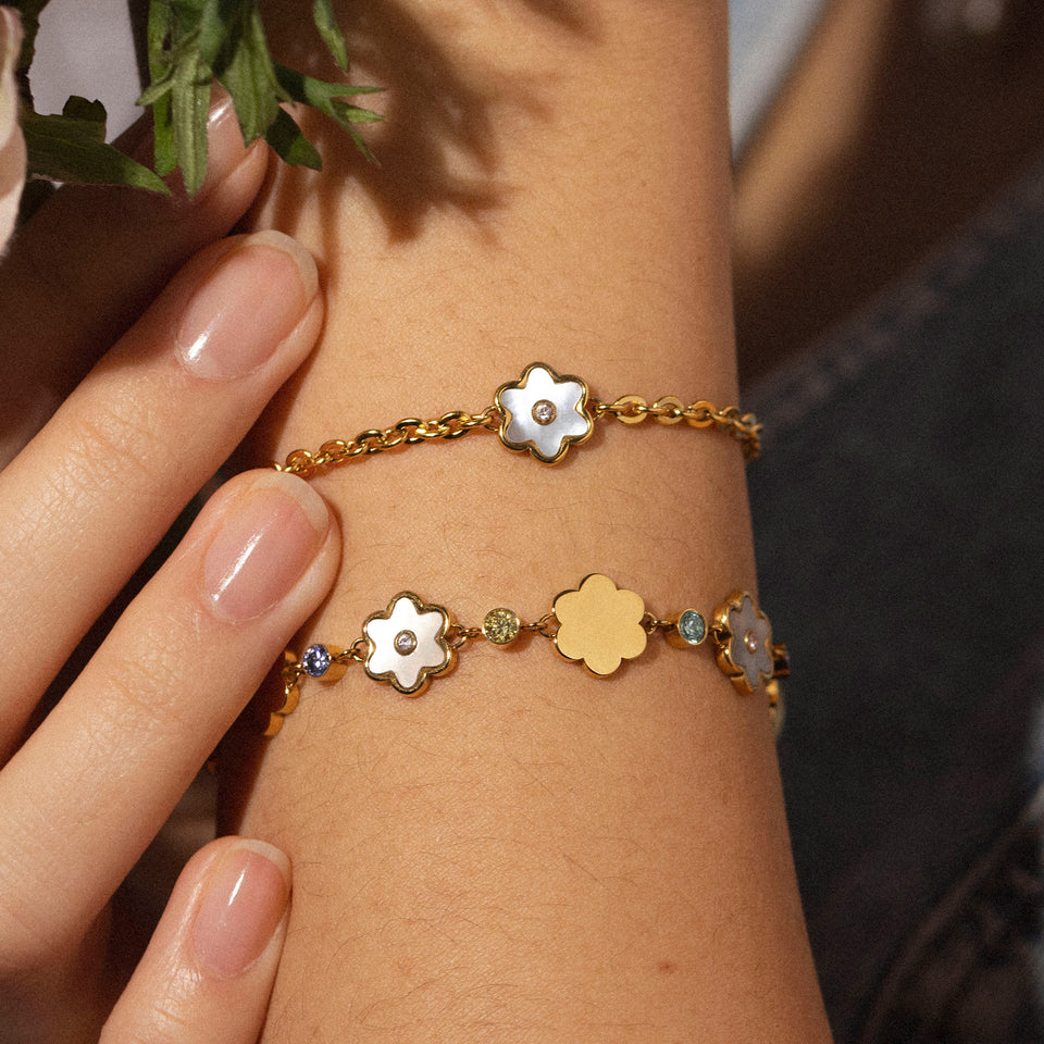 PURELEI Flourish Armband in Gold mit Blütenanhänger, Perlmutt und pinkem Zirkoniastein, elegant am Handgelenk.