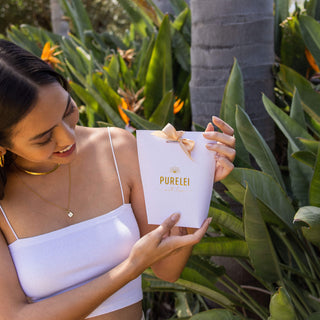 PURELEI Geschenkverpackung in Weiß mit goldener Prägung und Schleife, stilvoll gehalten und feminin inszeniert.