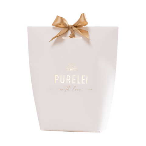 PURELEI Geschenkverpackung in Weiß mit goldener Prägung und Schleife, elegant und feminin gestaltet.