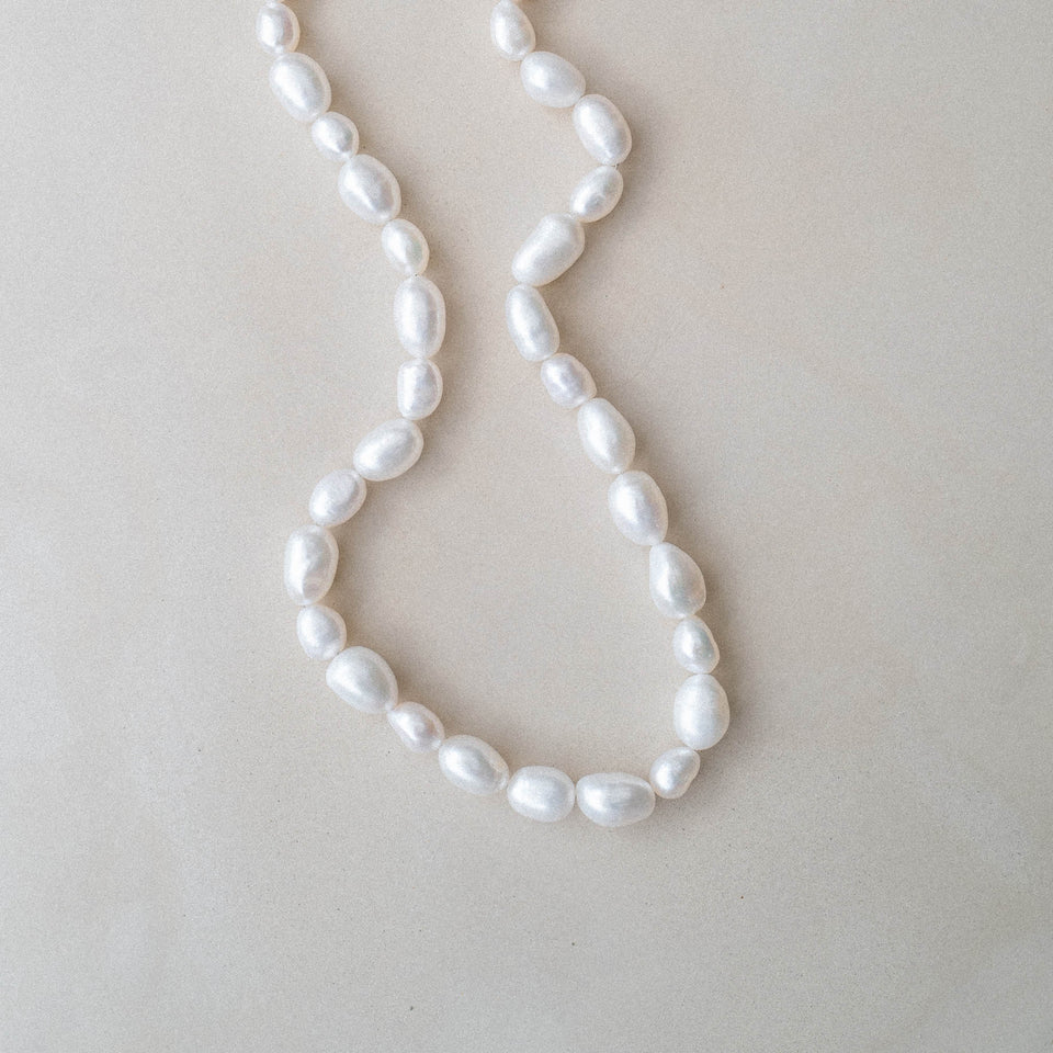 Moonlight Keshi Kette von PURELEI mit großen weißen Keshi-Perlen auf sanftem Leinen – elegant und feminin.