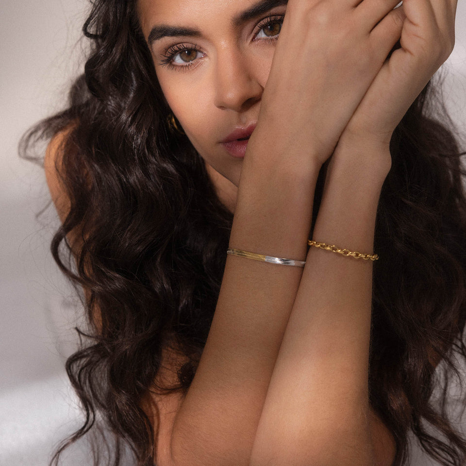 Bicolor Duality Armband von PURELEI in Gold und Silber, Schlangenketten-Design, elegant am Handgelenk getragen.