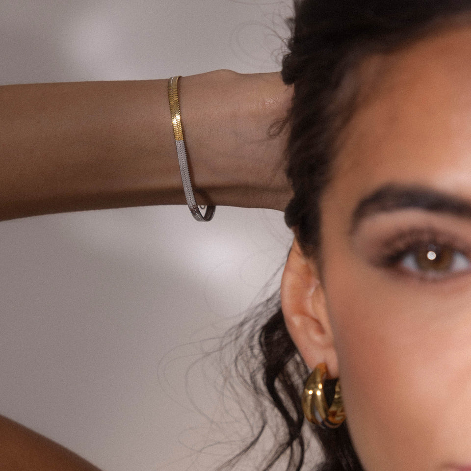 Duality Armband aus 18K vergoldetem und silbernem Edelstahl in Schlangenketten-Design am Handgelenk getragen von PURELEI.
