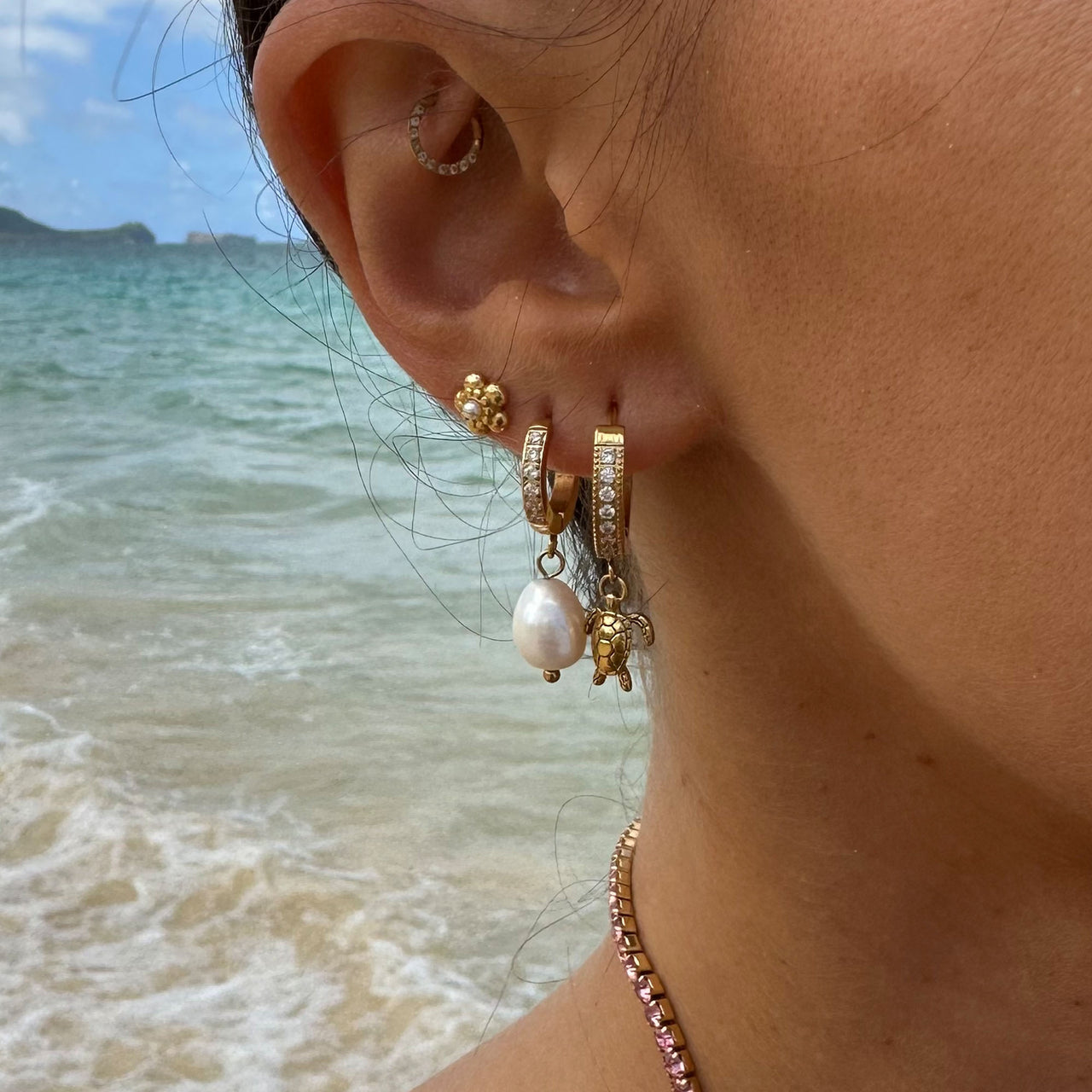 Malahi Ohrringe von PURELEI mit goldener Perle und Zirkonia, feiner Island-Spirit am Strand getragen, elegant und feminin