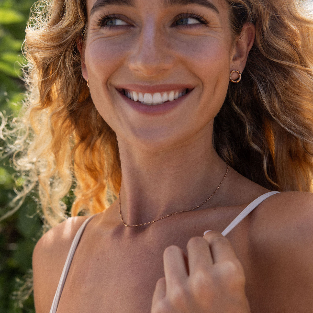 PURELEI Kaula Ohrringe aus 18K vergoldetem Edelstahl, minimalistisch und elegant im warmen Tageslicht getragen.