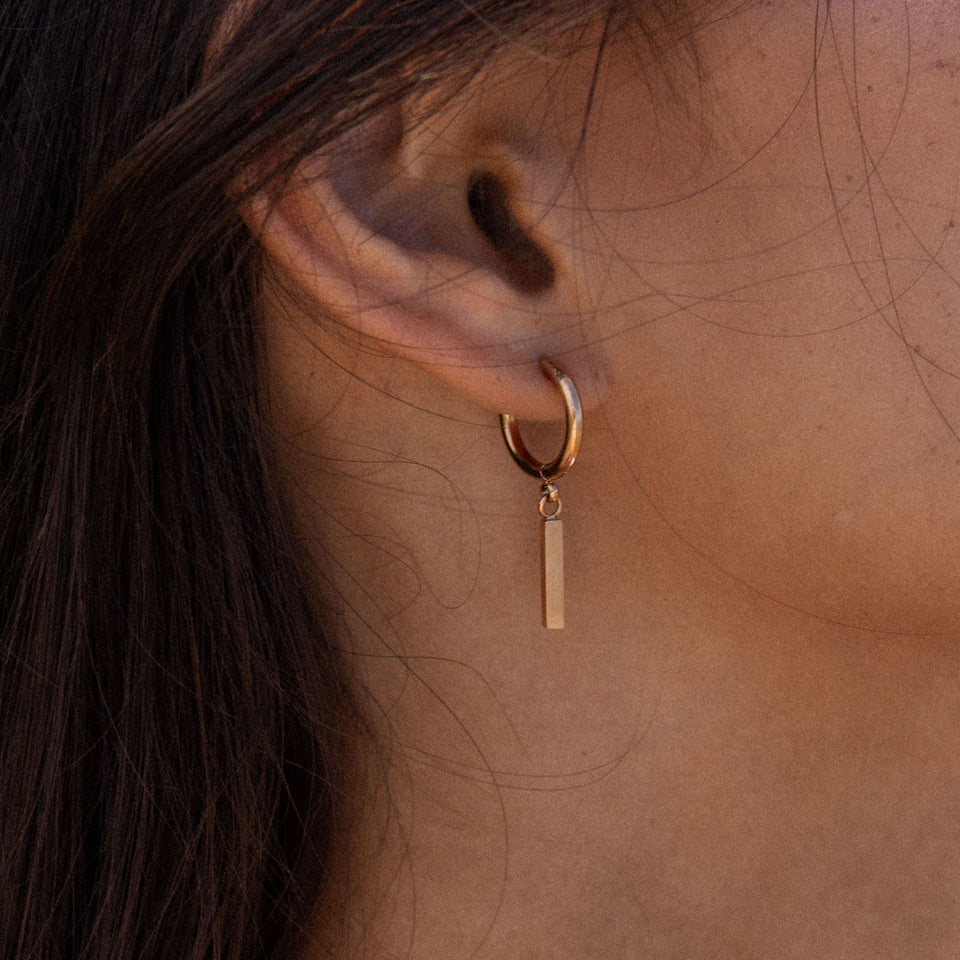 PURELEI Huli Creole Ohrringe aus 18K Gold mit rechteckigem Anhänger, elegant und feminin getragen am Ohr.