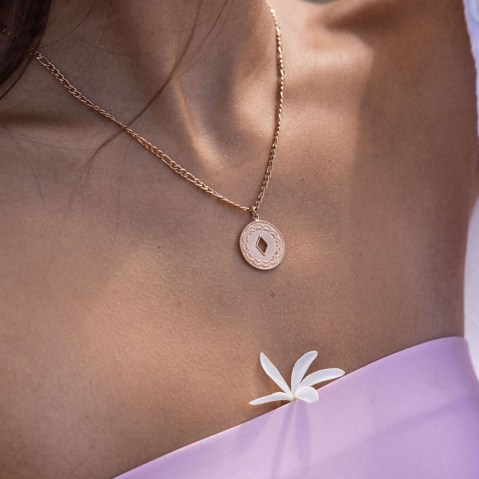Lolani Kette von PURELEI in Roségold mit gemustertem Coin-Anhänger, elegant am Hals getragen, feminine Leichtigkeit.