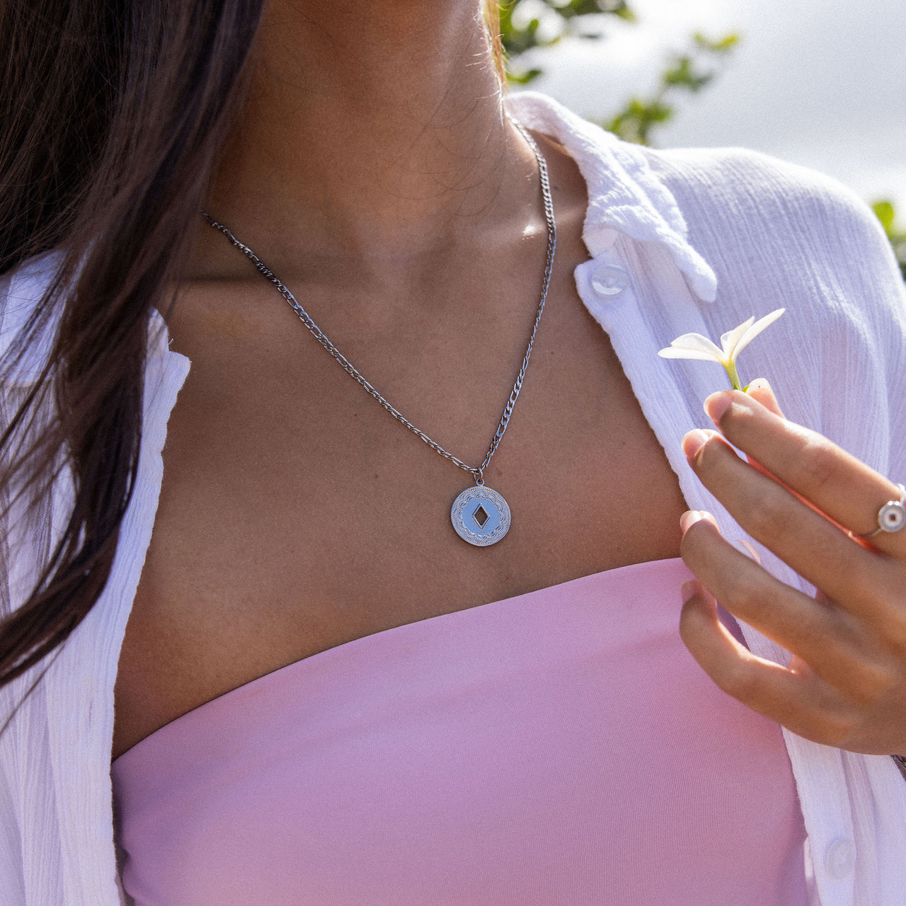 Silberne Lolani Kette mit gemustertem Coin-Anhänger, nickelfrei getragen in natürlichem, sommerlichem Licht von PURELEI