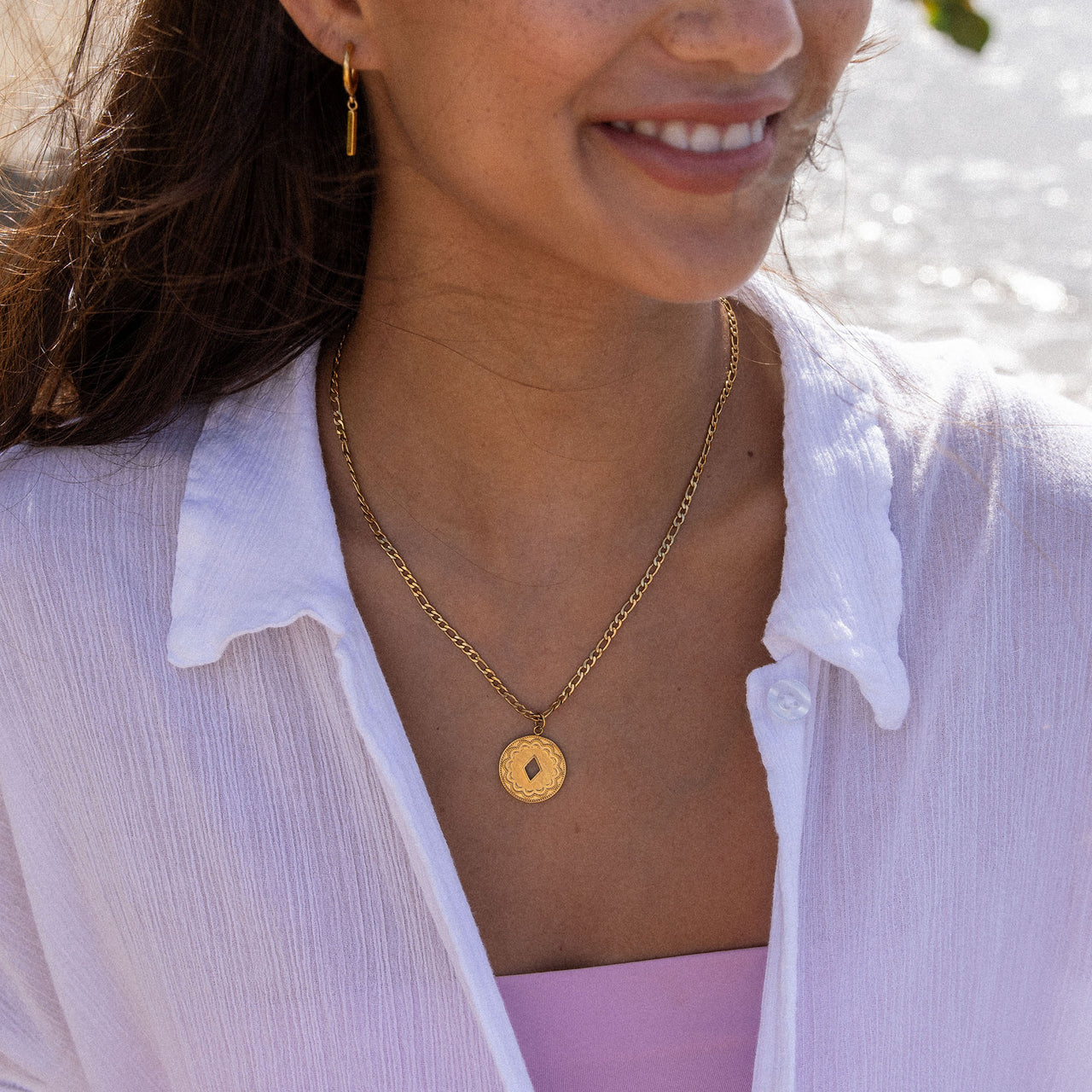 PURELEI Lolani Kette in 18K Gold mit gemustertem Coin und dezenter Ausstanzung, getragen am Strand, elegant und feminin
