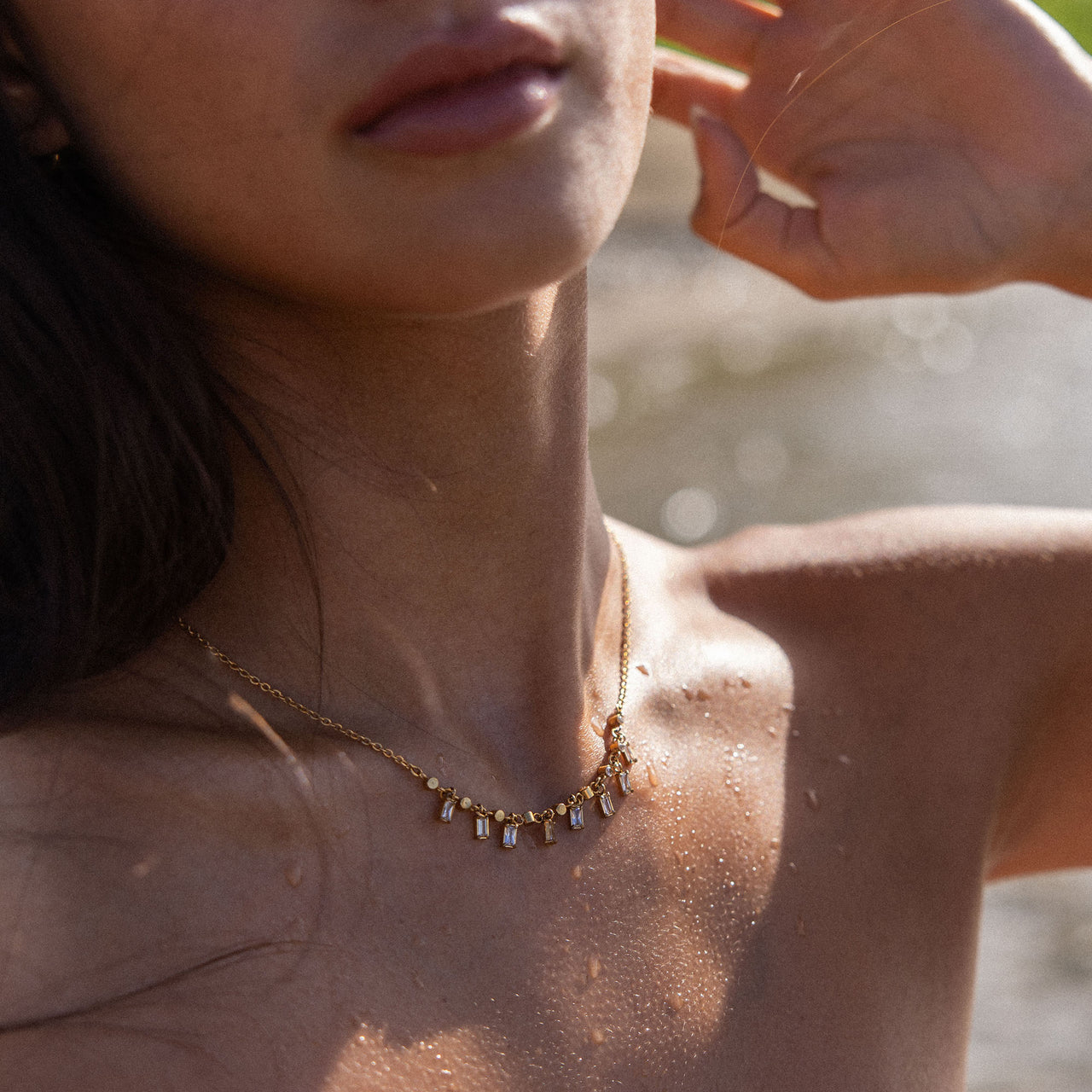 Shine Bright Kette aus 18K vergoldetem Edelstahl mit funkelnden Zirkonia, getragen am sonnengeplatzten Hals, PURELEI.
