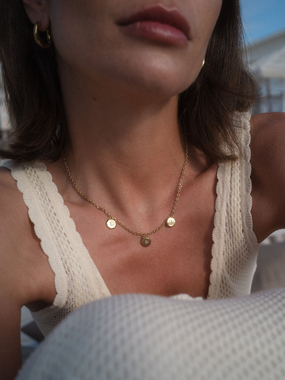 PURELEI Eternal Kette aus 14K Gold mit drei gravierbaren Anhängern, warm und feminin am Dekolleté getragen.
