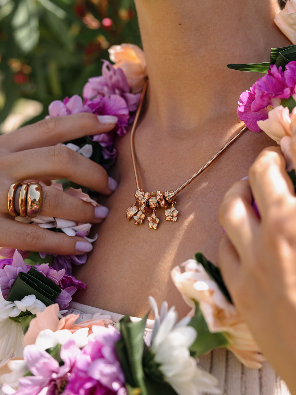PURELEI Lei Orchidee Charm in warmem Roségold mit filigranen Blüten und floralem Hawaii-Flair am Hals.