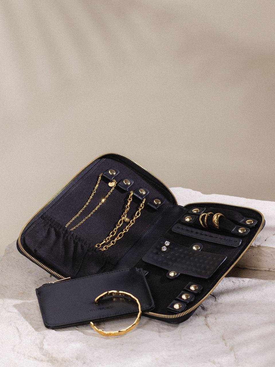 Schwarzes Schmuck-Reiseetui von PURELEI aus PU-Leder mit goldfarbenem Schmuck, elegant und praktisch unterwegs.