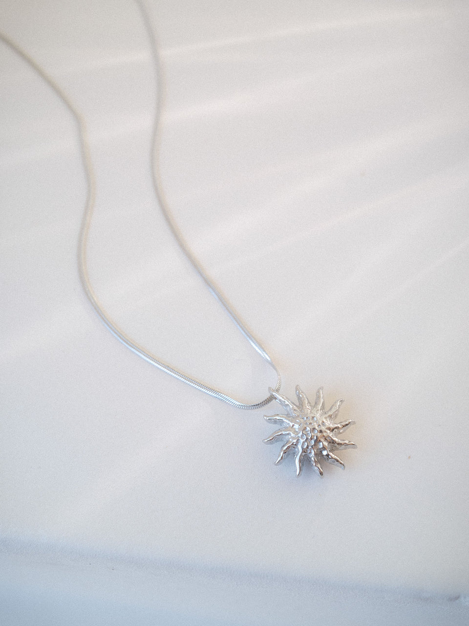 PURELEI Iconic Sun Kette in Silber mit filigranem Snake-Chain und strukturiertem Sonnenanhänger, elegant und feminin.