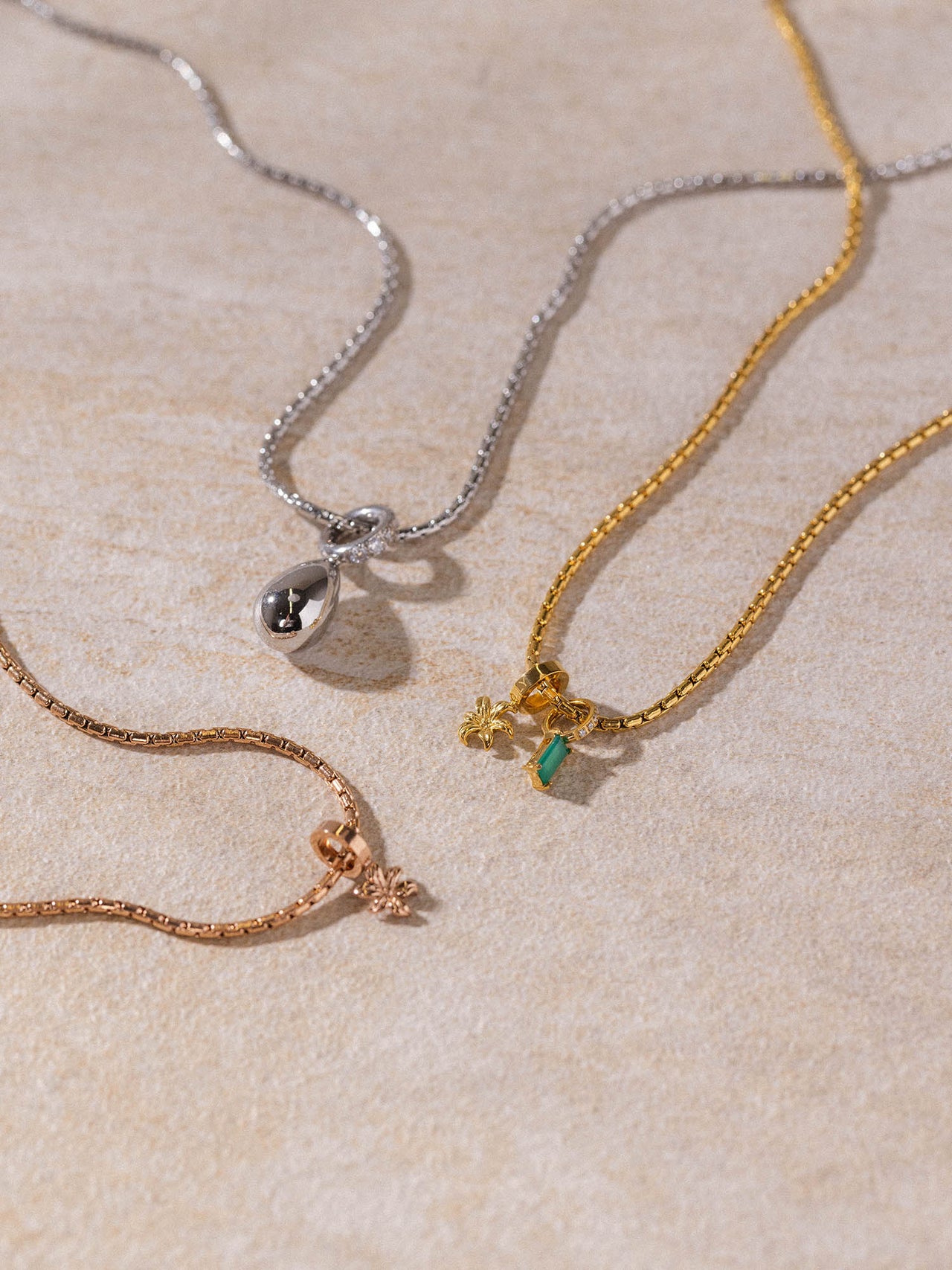 Resonance Kette von PURELEI in Gold, Silber und Roségold mit fein gearbeiteten Anhängern, clean & elegant inszeniert.