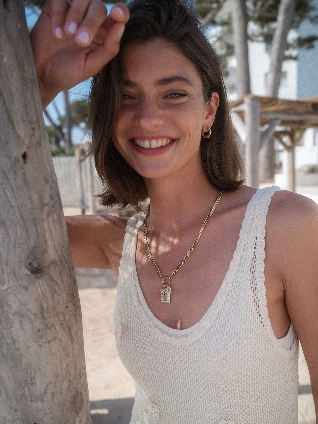 PURELEI Bold Charm Kette aus goldfarbenem Edelstahl mit Charm-Verschluss, getragen am Strand für elegante Leichtigkeit