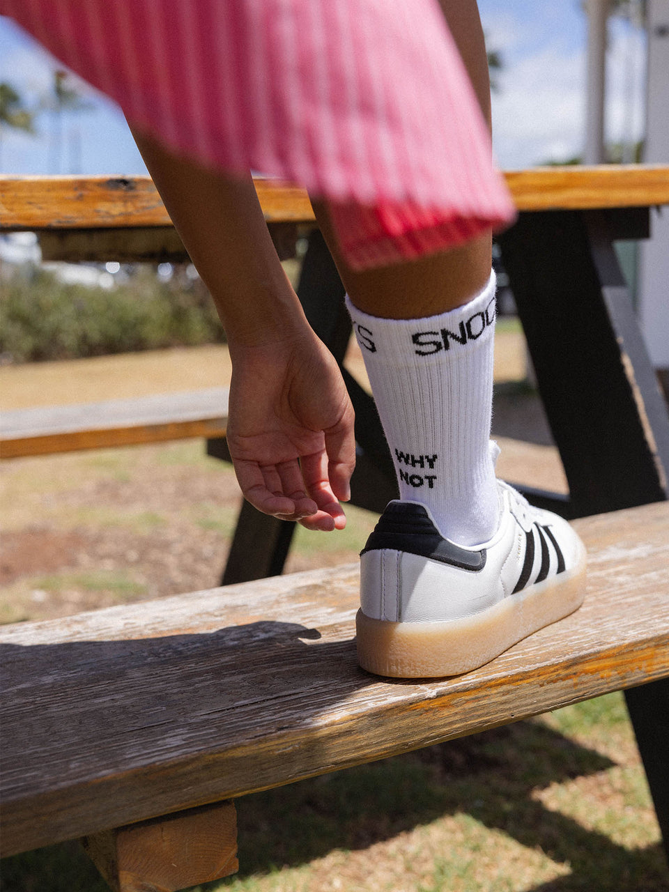 Tennissocken-Set aus Bio-Baumwolle mit schwarzem Schriftzug, casual getragen auf Holzbank im sonnigen Freien, PURELEI