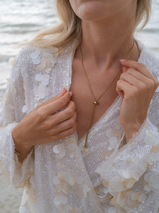 Roségoldene Kette mit zartem Anhänger, getragen in eleganter, glitzernder Umgebung – PURELEI.