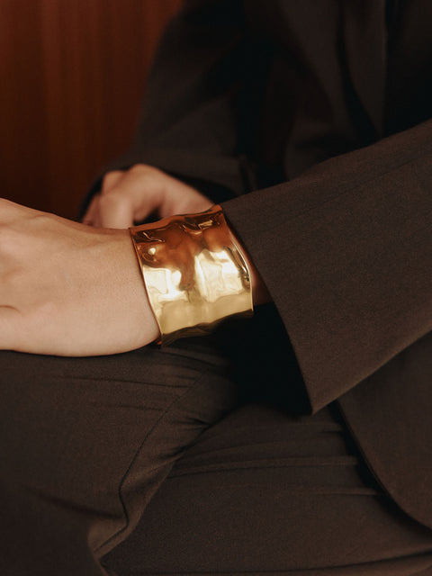 Elegantes, roségoldenes Armband mit geschwungener Form, getragen in stilvollem Ambiente – PURELEI.