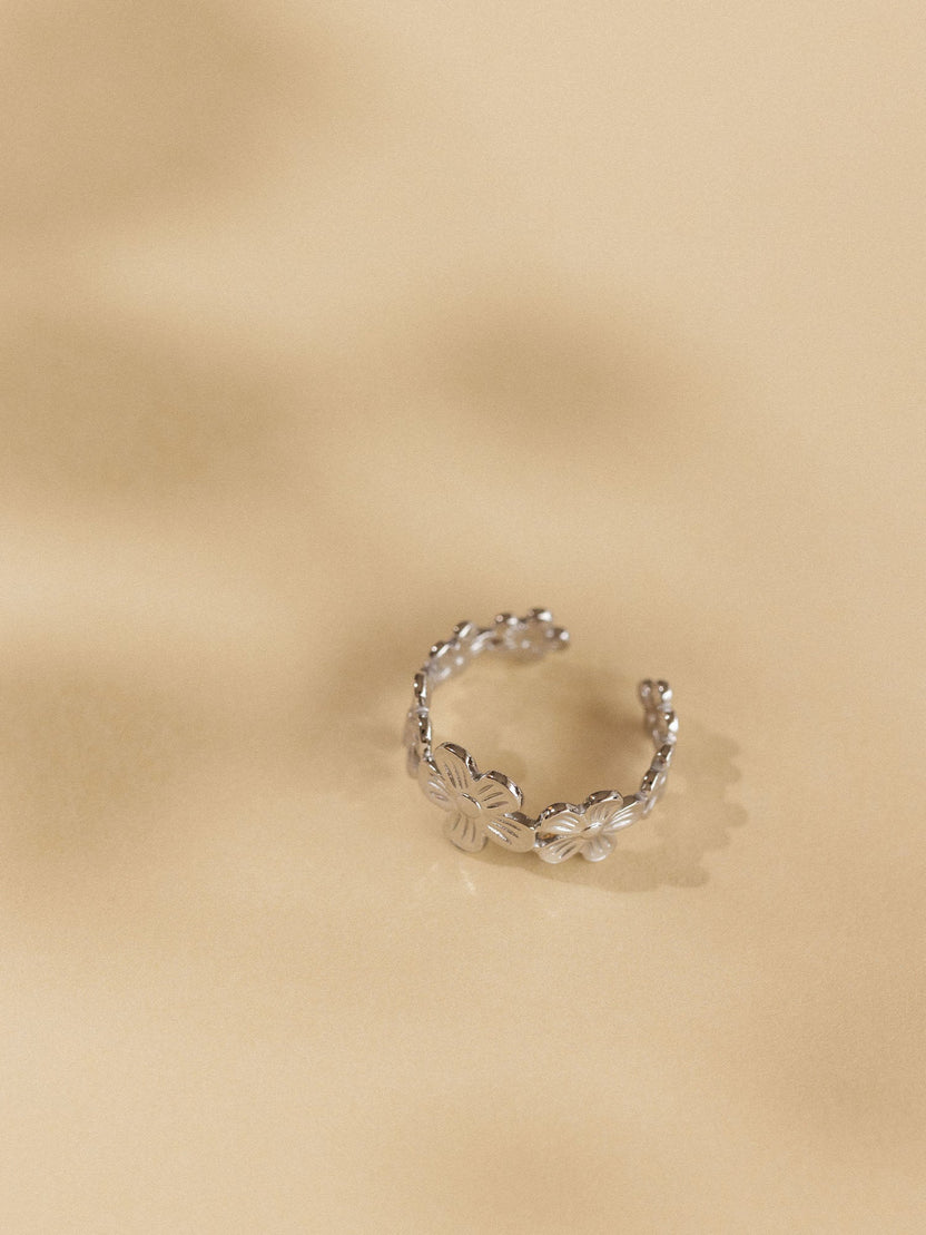 Goldener Ring mit floralen Details auf sanftem Hintergrund, PURELEI inspiriert.