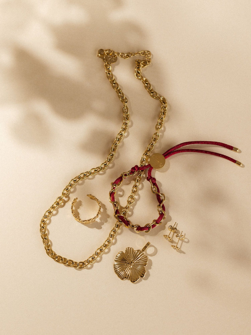 Goldene Kette, Armband und Ohrringe von PURELEI auf sanftem Hintergrund, elegant und feminin.