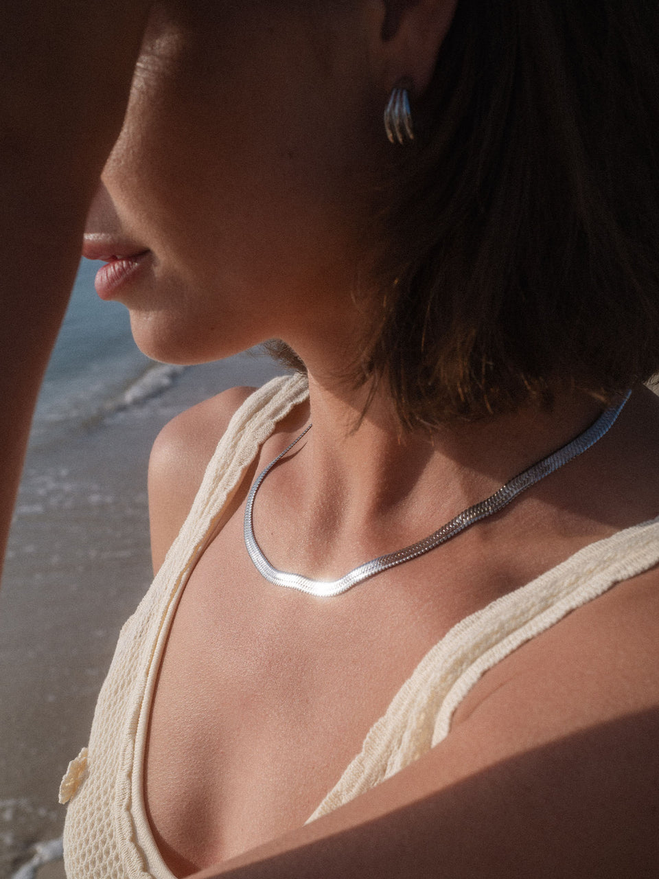 I’lalo Kette aus nickelfreiem Silber mit schlangenförmigem Design, getragen am Strand – elegant und zeitlos von PURELEI