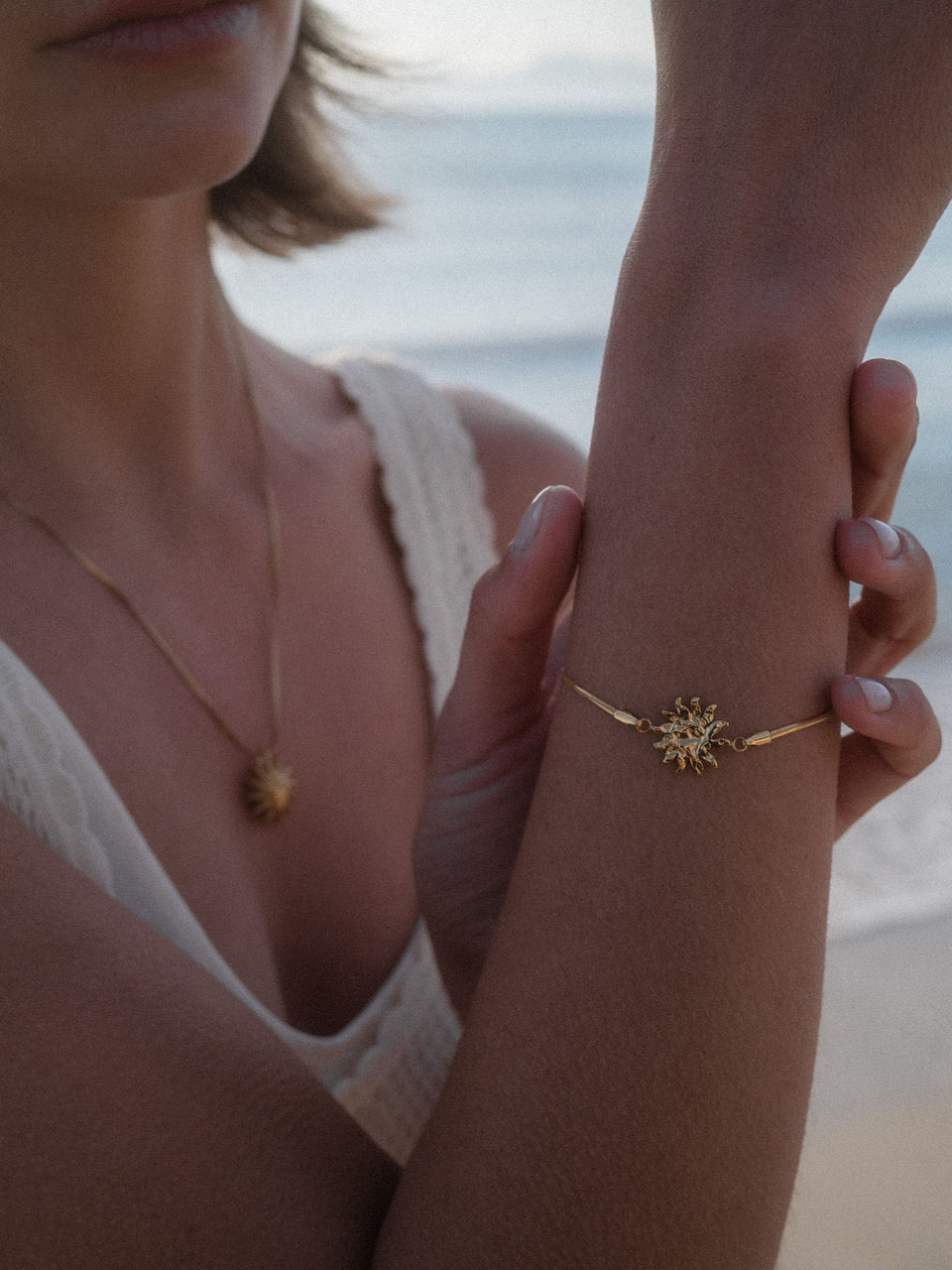 PURELEI Iconic Sun Armband aus 14K vergoldetem Edelstahl mit filigranem Sun-Charm, elegant am Handgelenk getragen.