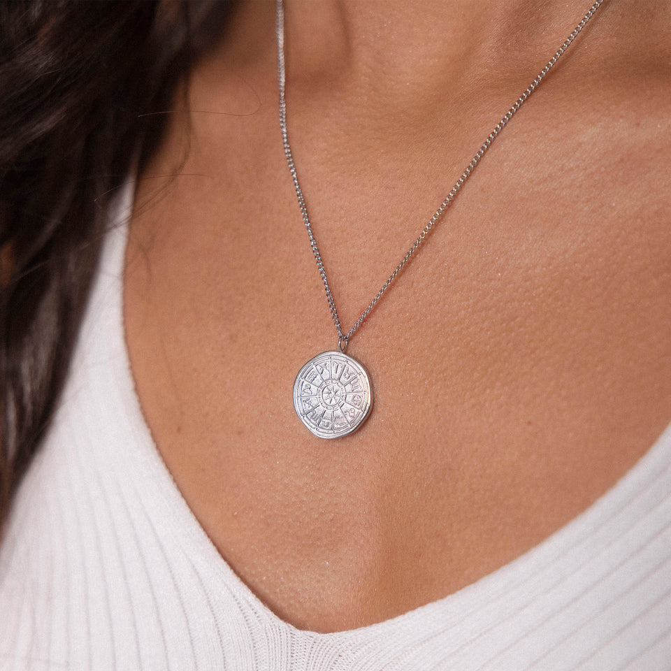 Zodiac Kette aus nickelfreiem Silber mit feinem Sternzeichen-Anhänger, getragen zu weißem Shirt, pure Eleganz von PURELEI
