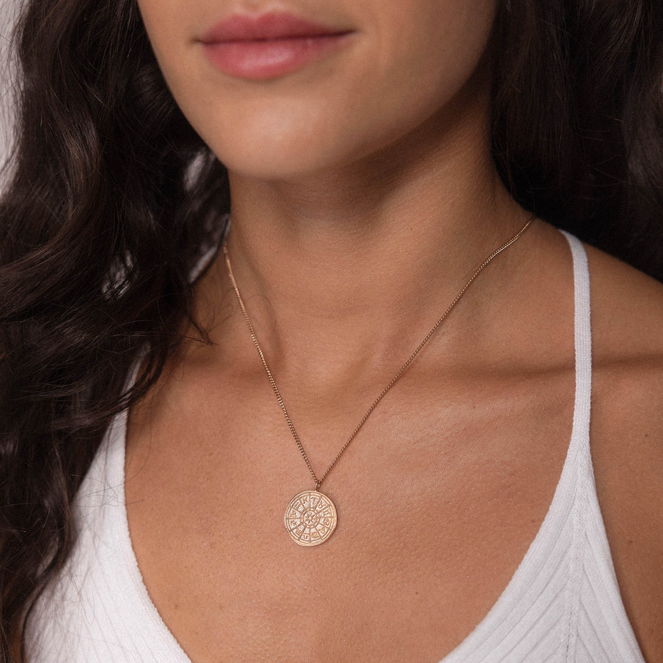 Zodiac Kette von PURELEI, zarte 18K Roségoldvergoldung, Sternzeichen-Anhänger, elegant und feminin am Dekolleté getragen.