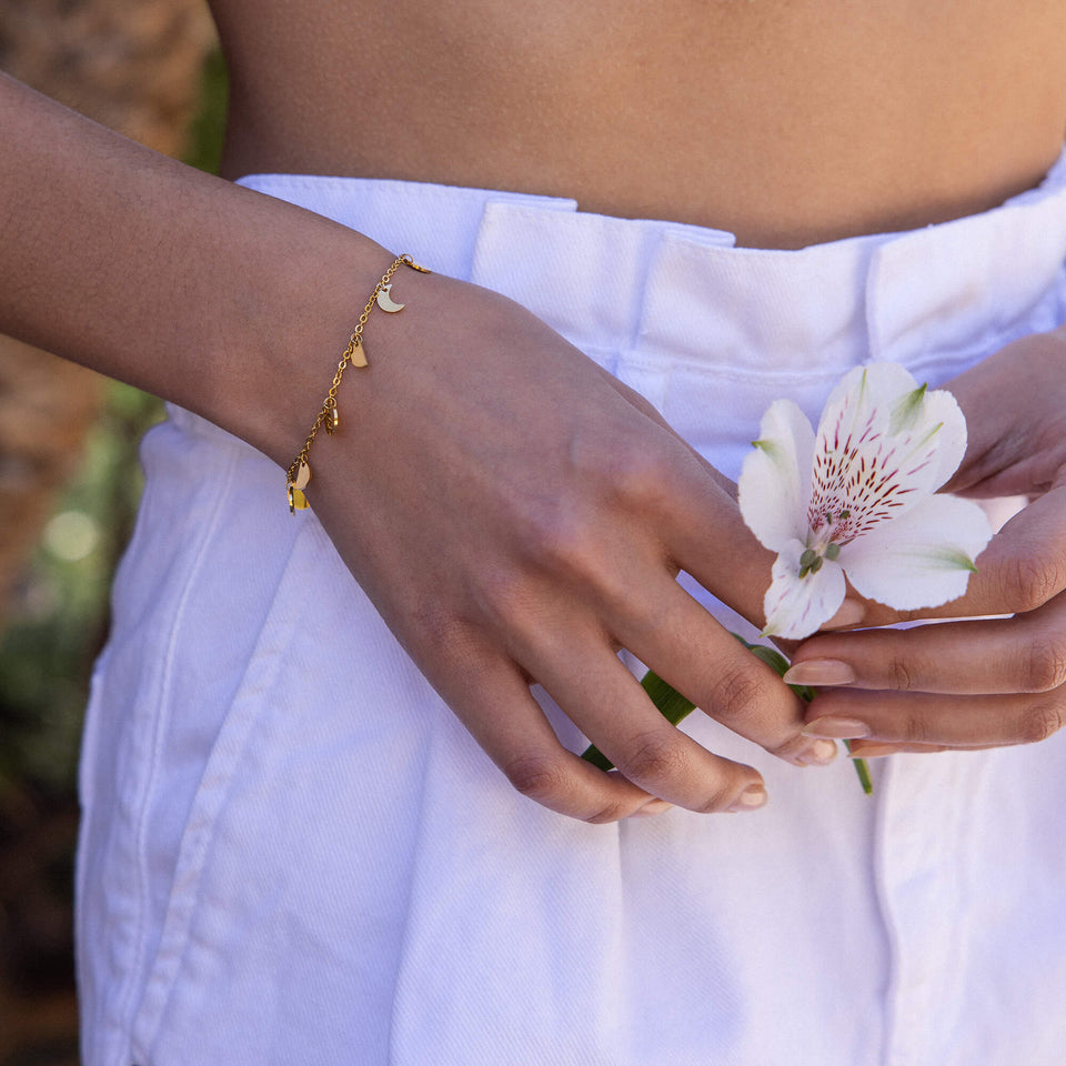 PURELEI Luna Armband aus 18K Gold mit Mond- und Herz-Anhängern, zart am Handgelenk getragen, feminine Eleganz.