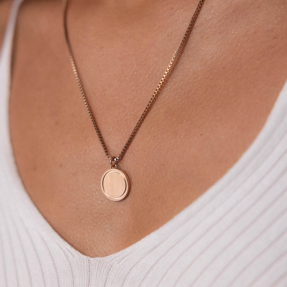 PURELEI Love Letter Kette in Roségold mit rundem Anhänger, elegant getragen zu weißem Oberteil, feminin und zeitlos