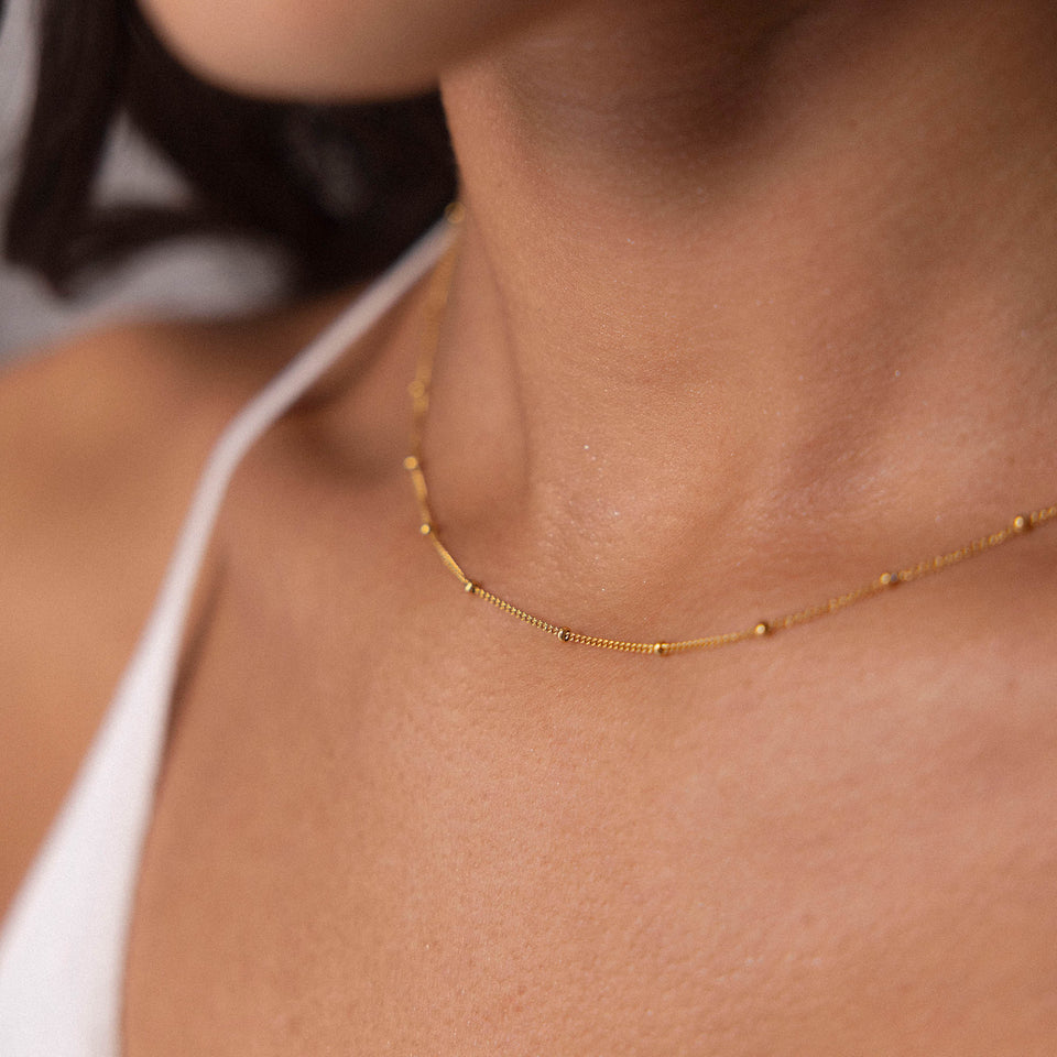Feingliedrige Li’ili’i Kette aus vergoldetem Edelstahl, zart am Hals getragen, elegant und minimalistisch von PURELEI.