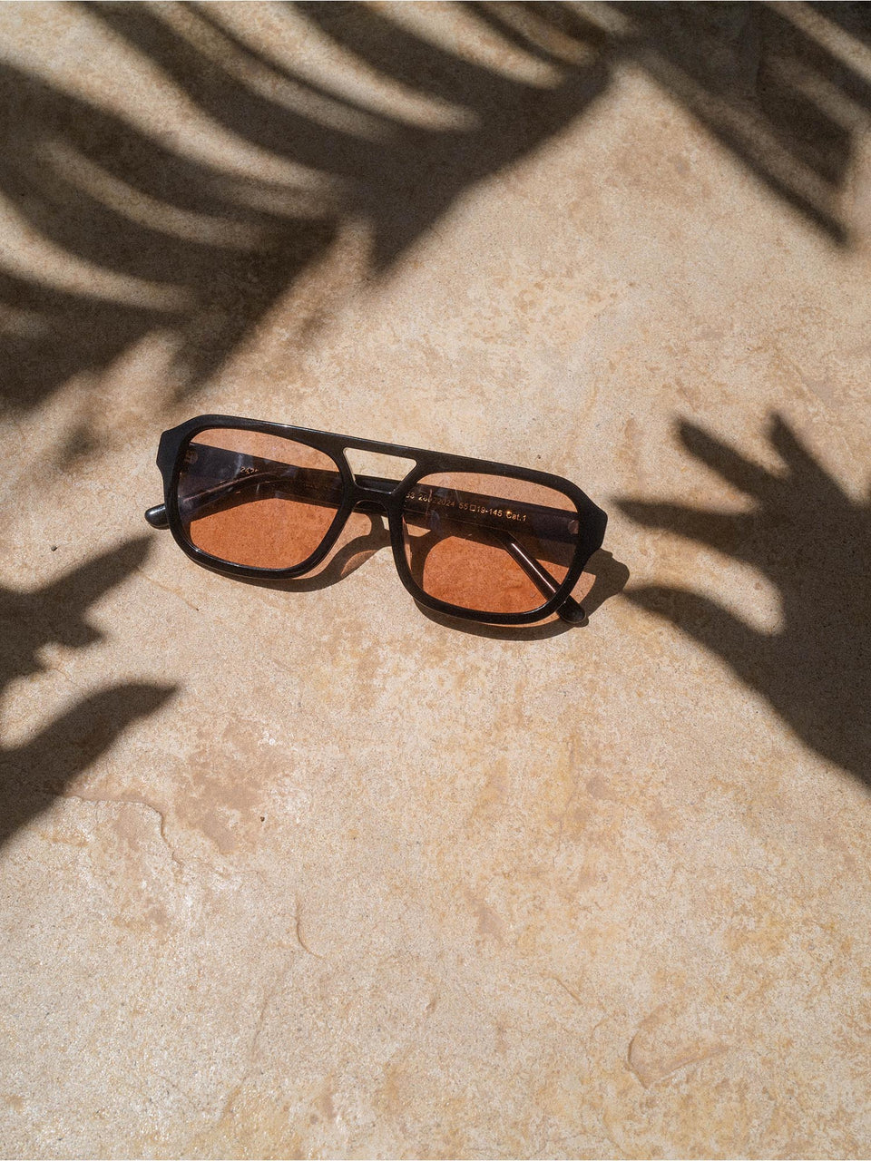 Summer Haze Sonnenbrille von PURELEI mit schwarzem Acetat-Rahmen und braunen Gläsern in sonniger, natürlicher Atmosphäre
