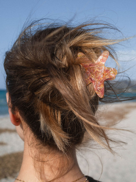 Starfish Haarklammer aus schimmerndem Acetat mit goldenen Punkten in den Haaren am Strand von PURELEI