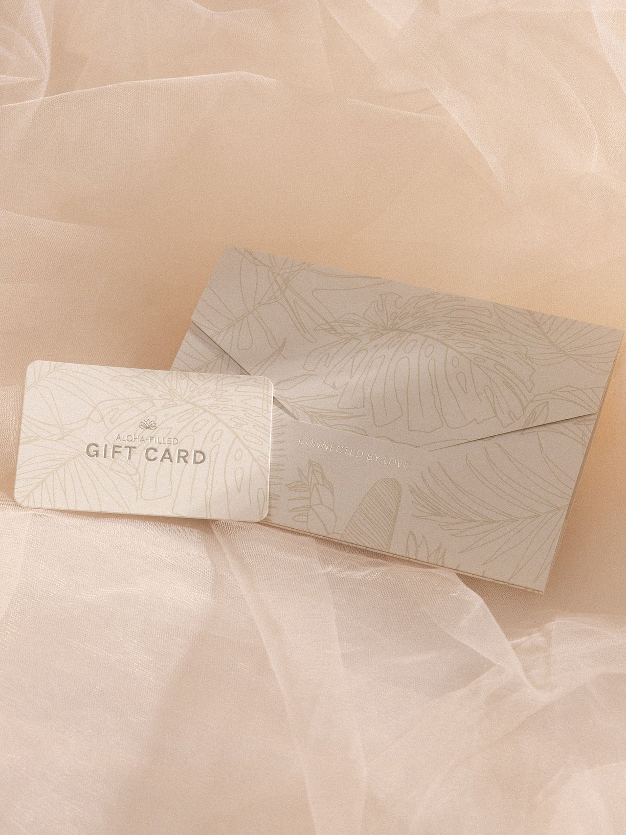 Gutschein in Geschenkumschlag mit floralem Design auf feinem Stoff, elegant und feminin, PURELEI-Ästhetik.