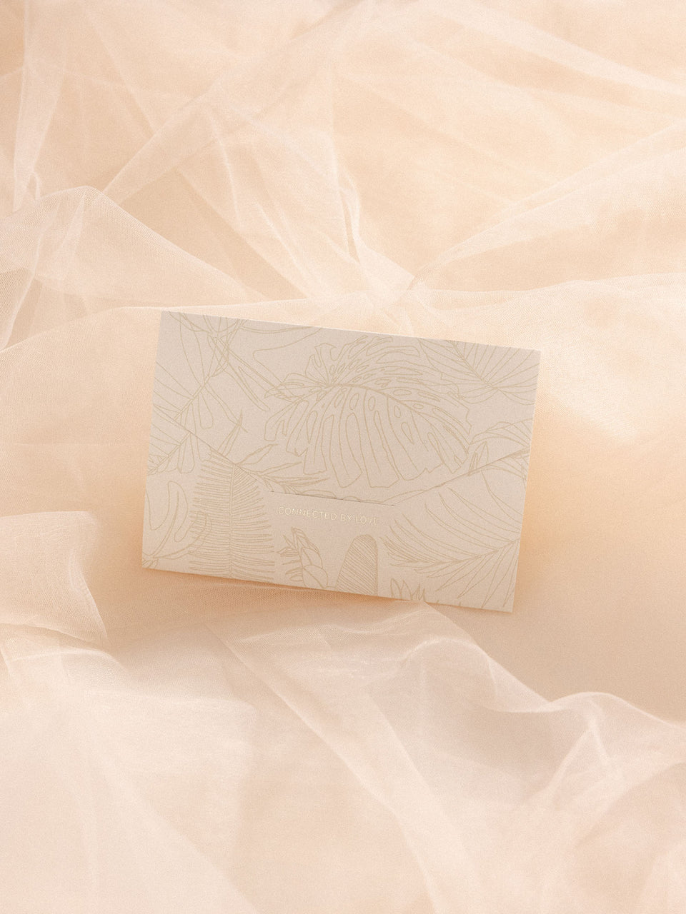 Gutschein in Geschenkumschlag mit floralen Mustern, zart auf hellem Stoff, PURELEI elegant und feminin.